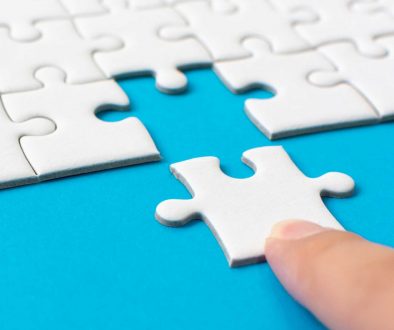 vecteezy_hand-putting-piece-of-white-jigsaw-puzzle-on-blue-background_3436637